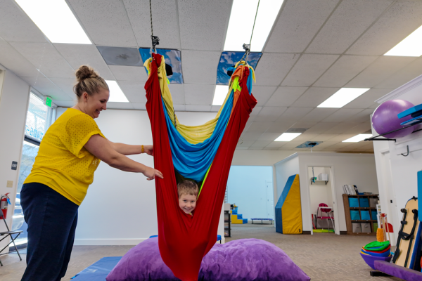 boy-happily-swining-in-colorful-hammocks-during-physical-therapy-in-roseburg-oregon