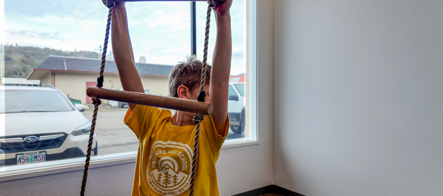 boy-in-yellow-shirt-and-jeans-climbing-indoors-for-physical-therapy-in-childrens-clinic-safe-environment