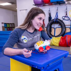 harlee-armiger-office-manager-e3-playing-with-red-toy-phone-while-sitting-in-childs-desk-e3 harlee-armiger-office-manager-e3-playing-with-red-toy-phone-while-sitting-in-childs-desk-e3