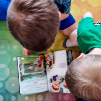 two-boys-quietly-reading-a-book-on-a-colorful-rug-at-explore-engage-enjoy-pediatric-therapy-clinic-roseburg-OR two-boys-quietly-reading-a-book-on-a-colorful-rug-at-explore-engage-enjoy-pediatric-therapy-clinic-roseburg-OR